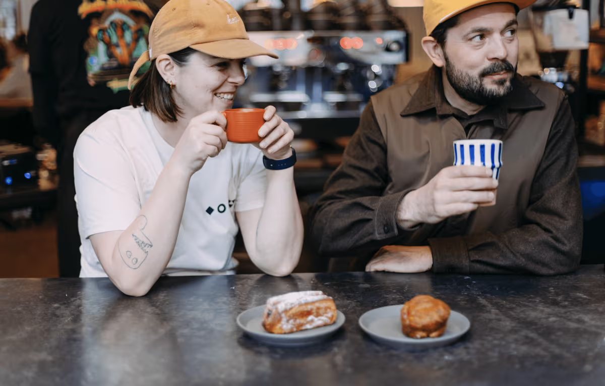 Twee mensen van WAY drinken koffie aan de toog