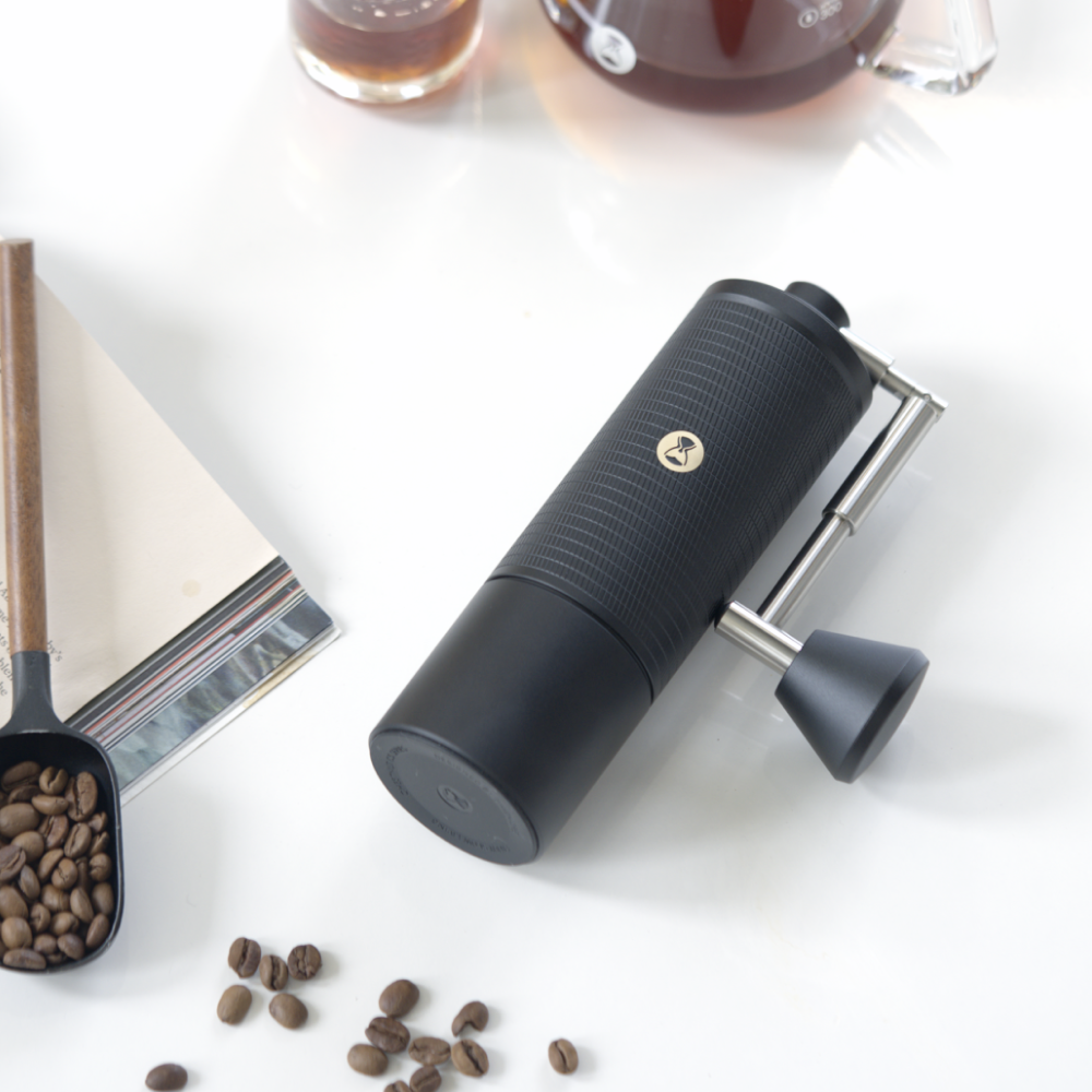 TIMEMORE C5 Pro liggend op tafel, met koffiebonen en een maatschepje