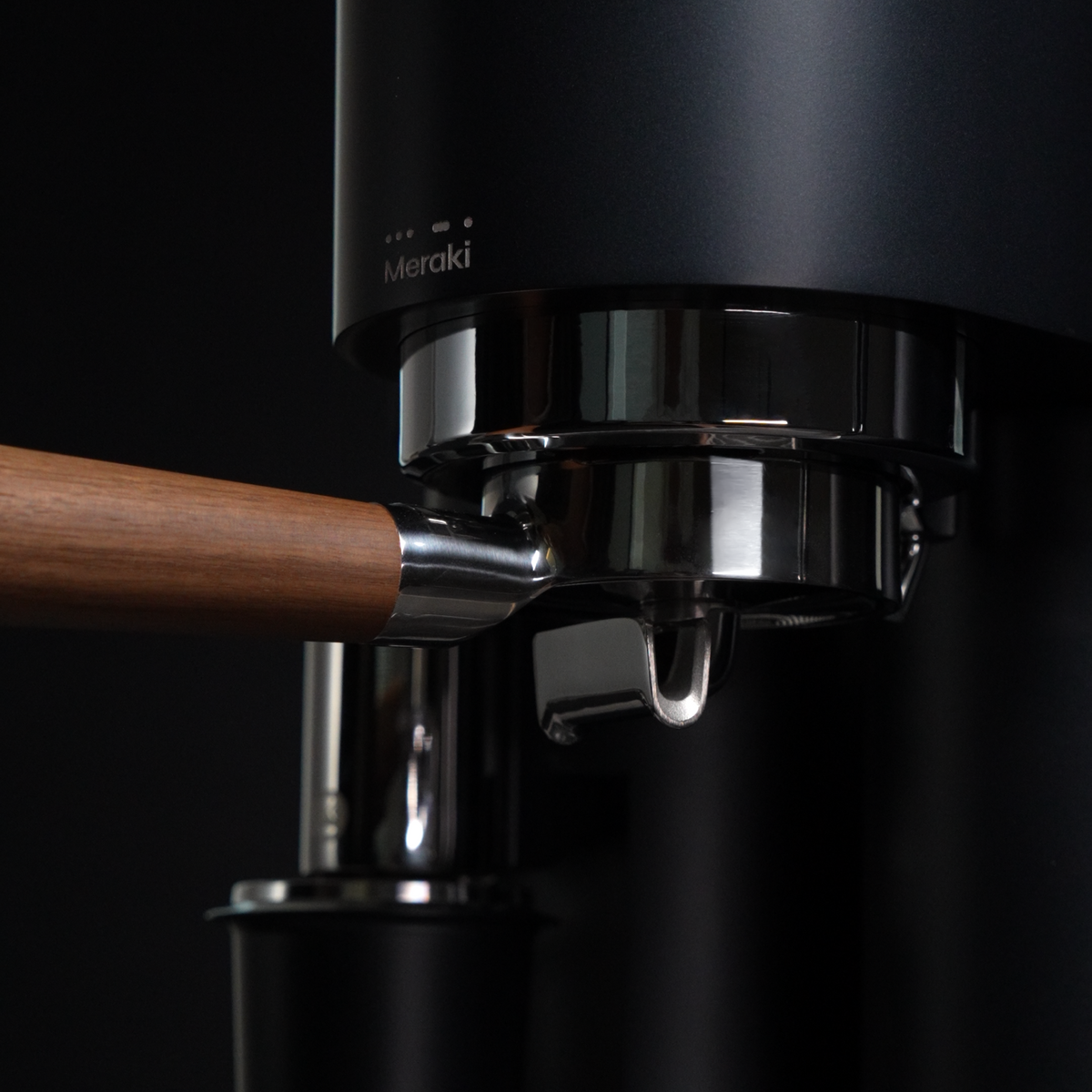 Detail van de verwarmde groep en de 58 mm portafilter met houten greep van de MERAKI Gen 2
