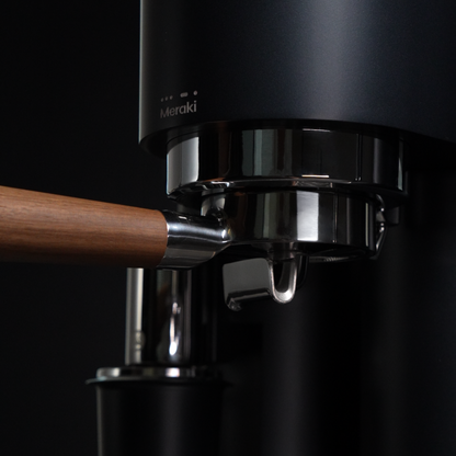 Detail van de verwarmde groep en de 58 mm portafilter met houten greep van de MERAKI Gen 2