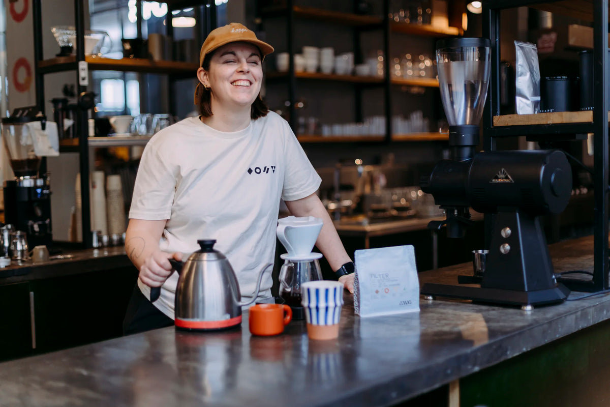 Barista met filterkoffie-opstelling achter de toog